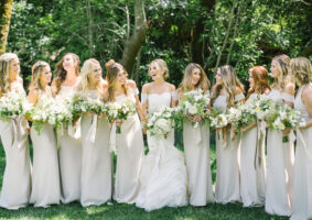Noiva e damas usando branco em casamento.